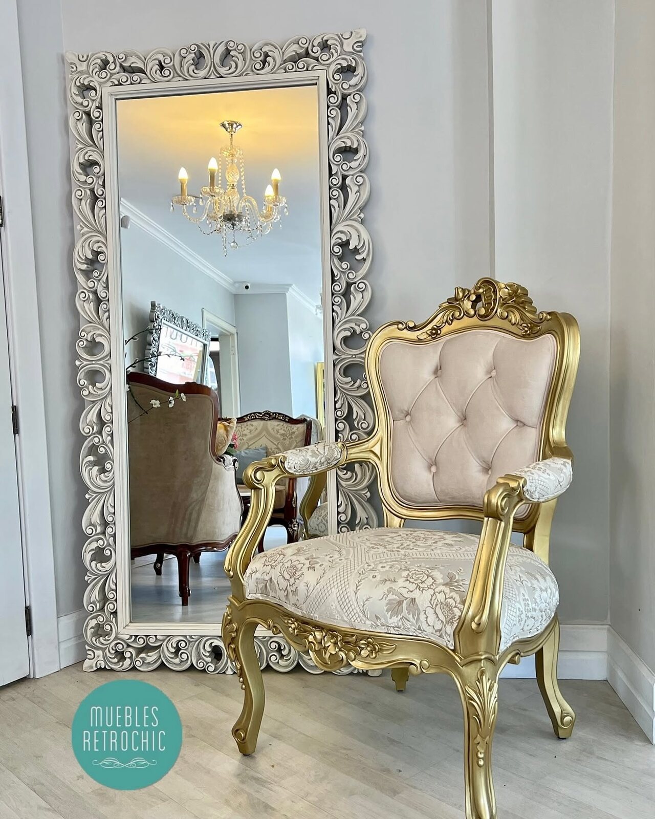 Ivory Louis XV armchair beside a silver-toned mirror